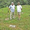 Gaye Moore and her husband, David, look at one of the many historic graves in the Mullins-Sturgill cemetery. One of their sons does much of the work to keep the historic graveyard free of vegetation. JODI DEAL PHOTO.Click Hereto order photo reprints