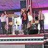 Speakers and audience members alike rose to their feet, holding their hands aloft and swaying, as Diane Collins sang 'God Bless the U.S.A' Saturday during a Southwest Virginia Tea Party rally at Zion Family Ministries.