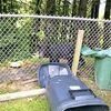 The young bear cub can be seen on the far side of the chain link fence, just behind the trash can lid. NORTON POLICE PHOTO JOE BAIRD.