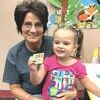Caroline Perry with her grandmother Lisa Moore shows off her ne library card.